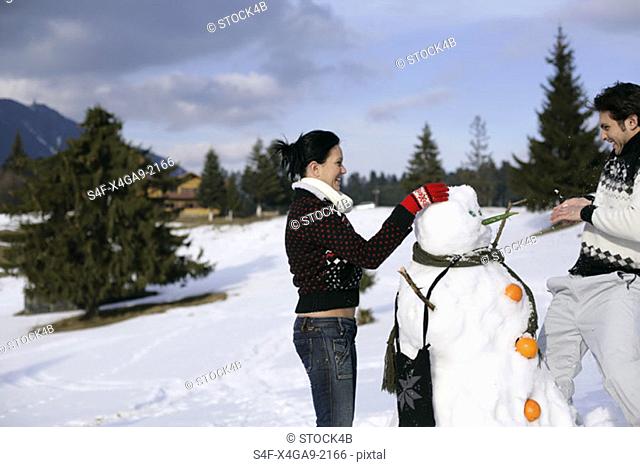 Young couple making a snowman