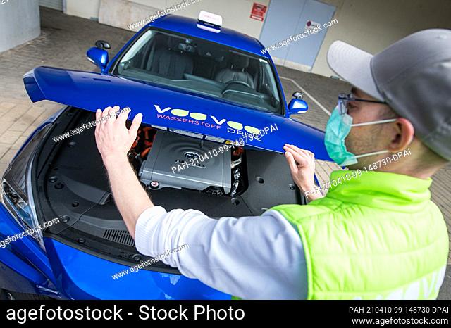 08 April 2021, Saarland, Saarbrücken: Driving instructor Rouven Klein closes the bonnet of his hydrogen driving school car