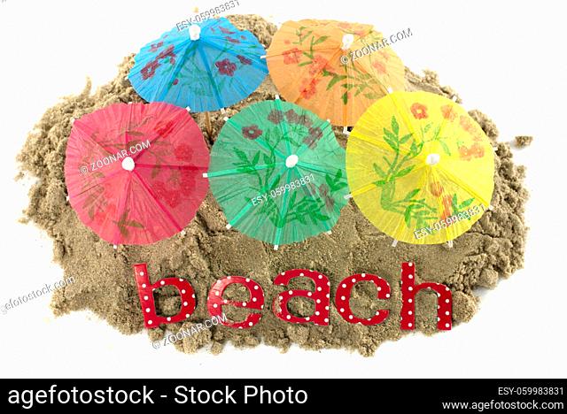 yellow orange blue red and green cocktail Umbrellas in Sand Mound