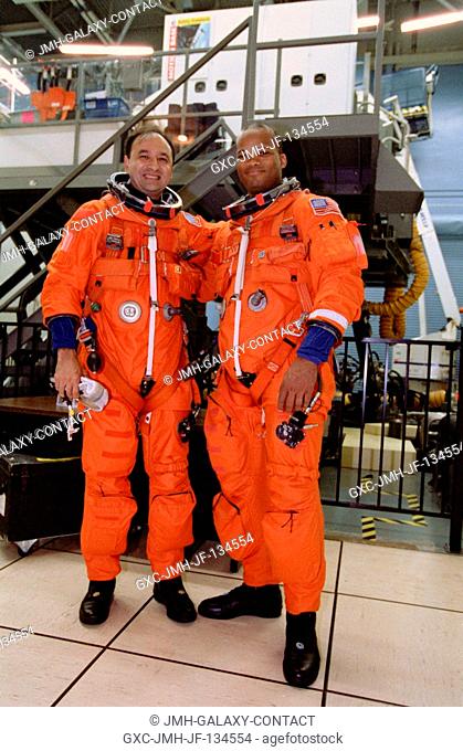 Attired in training versions of the shuttle launch and entry garment, astronauts Mark Polansky (left) and Robert L. Curbeam take a break from a simulation...