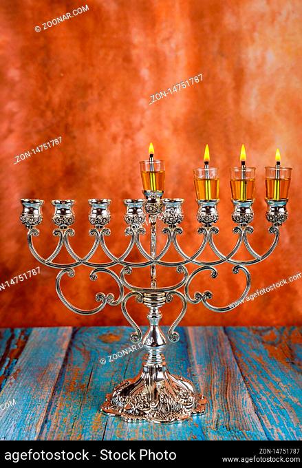 Lights candles on the third day of the Jewish holiday Hanukkah. candles are burning on light of menorah