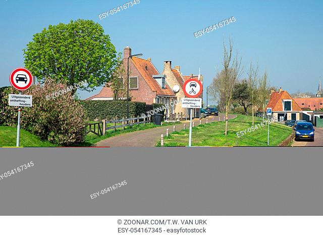 Traditional houses with road signs in Makkum, historic Dutch fishing village in Friesland