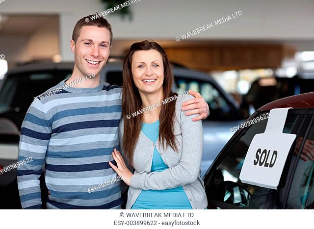 Couple purchasing a new car in a dealership