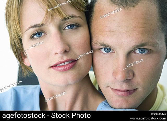 Woman and man smiling at camera with white background
