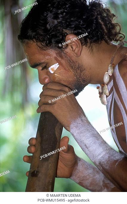 Young aboriginal man playing a didgeridoo