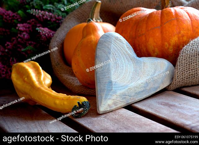 Kürbisse im Jutesack, Herbstdeko und ein Herz auf verwittertem Holz