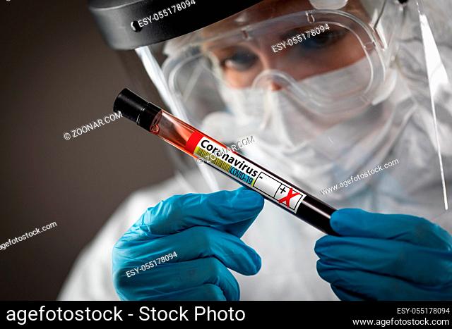Female Lab Worker Holds Test Tube of Blood Labeled Coronavirus COVID-19 Disease