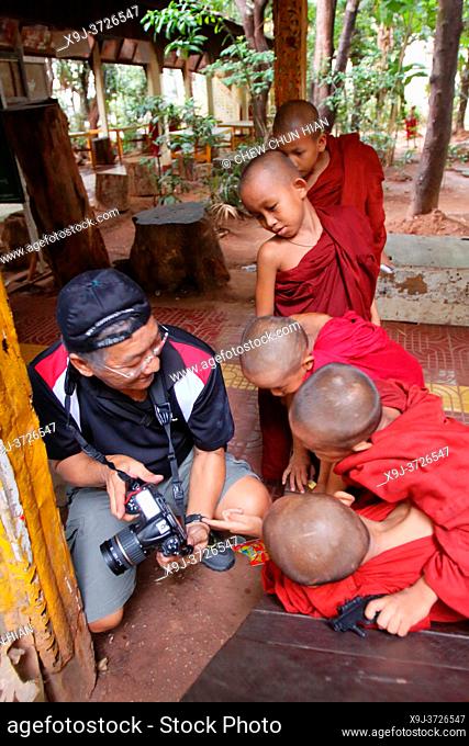 Tourist show the snap photo to the Novice monks in the Shwe Yaunghwe Kyaung Monastery, near Nyaungshwe, Shan State, Myanmar