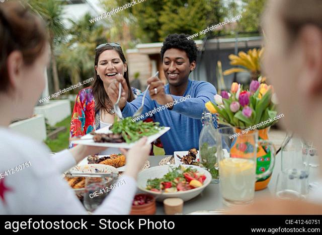 Friends enjoying vegetarian lunch at patio table