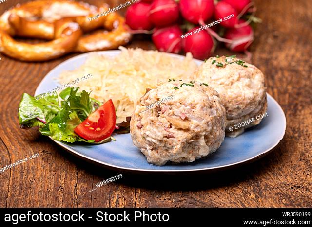 two speckknoedel with sauerkraut on wood