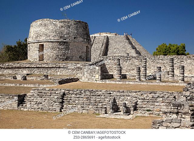 View to the Templo Redondo-Round Temple and to the visitors climbing up to the Castle of Kukulcan-Castillo de Kukulcan in the background in Mayapan...
