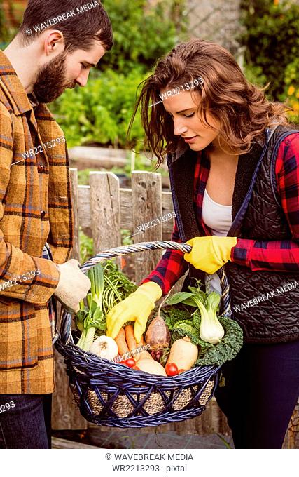 Couple looking at basket of vegetable