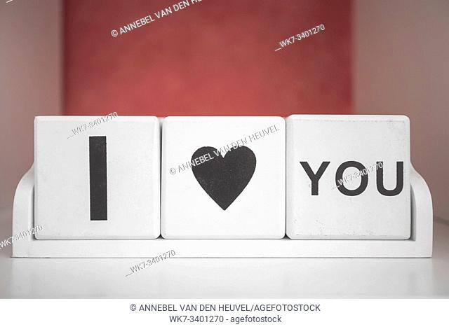 Three wood cubes with I love you words on wooden table , valentine background template romantic