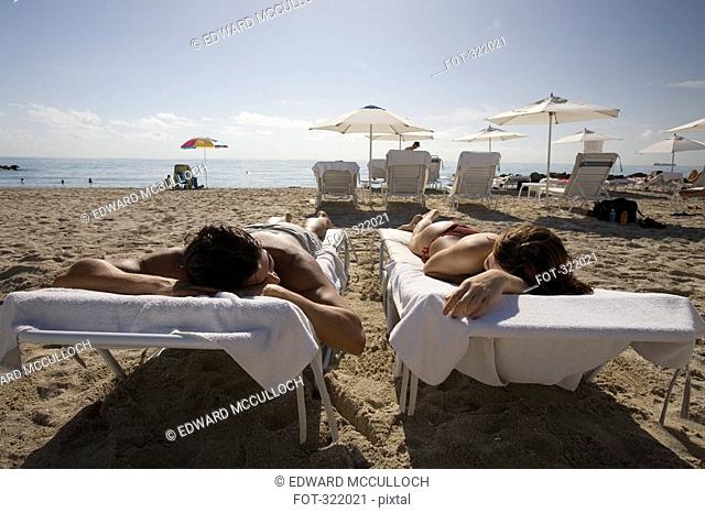 Couple sunbathing on the beach