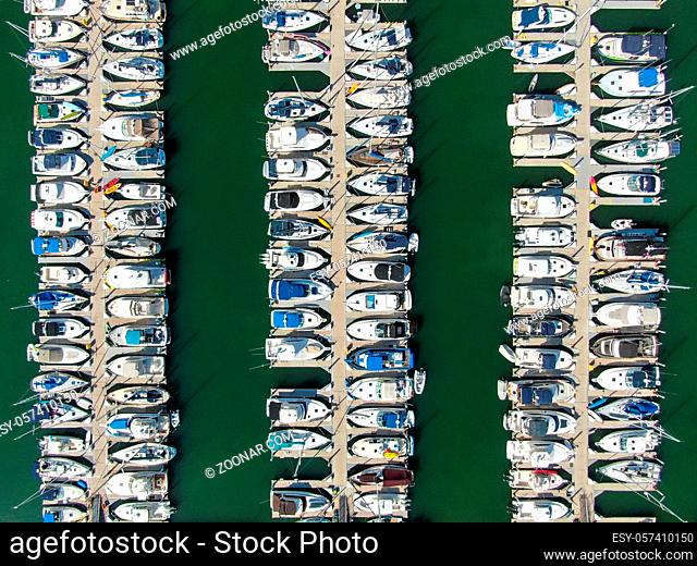 Aerial top view of boats and yachts in marina. Marina lot with yachts, sailboat and speedboat moored at the quay