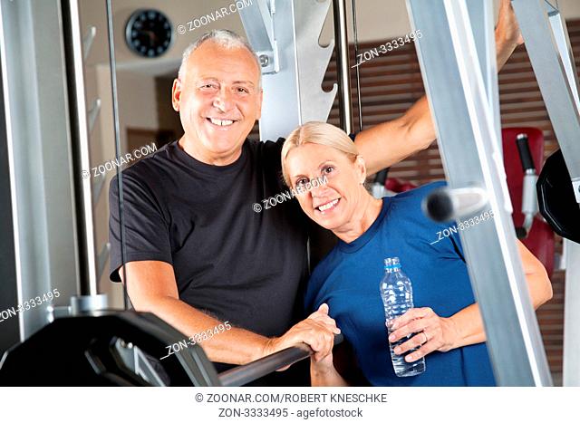 Lachendes aktives Seniorenpaar trainiert im Fitnesscenter