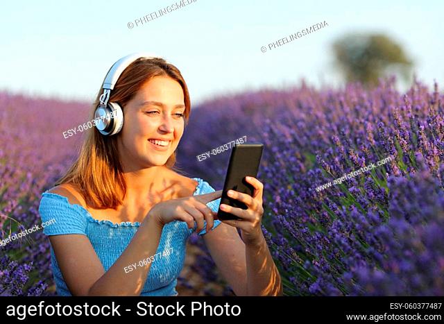 Happy woman listening to music in lavender field