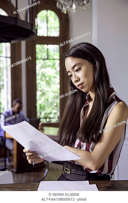 Woman reading document in office
