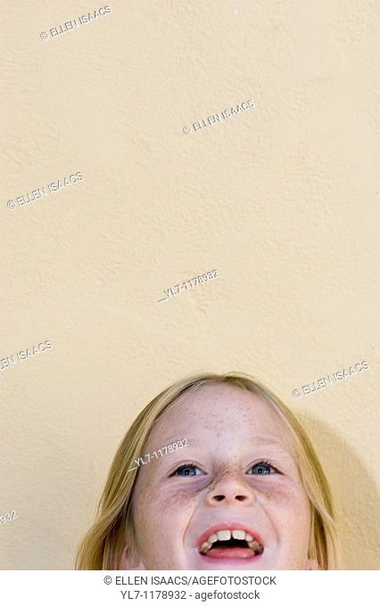 Top of a nine-year-old blond girl's head, laughing and looking up