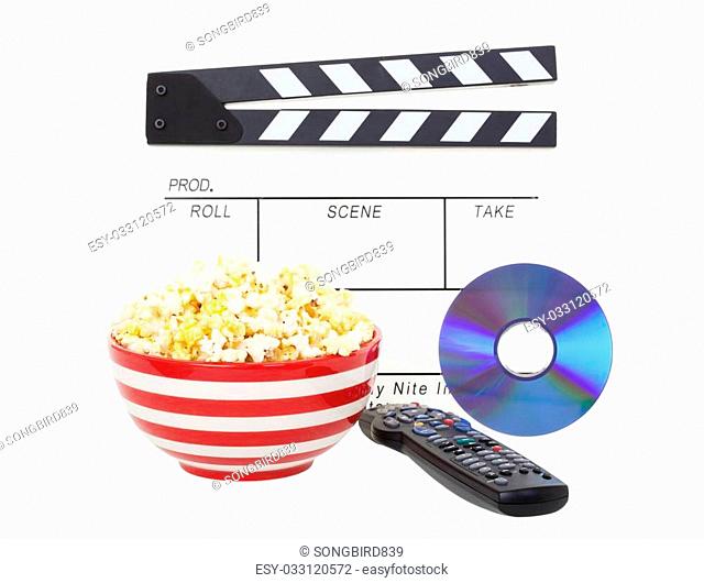 Movie night theme. A bowl of fresh popcorn, with clapper board, movie and television remote. Shot on white background