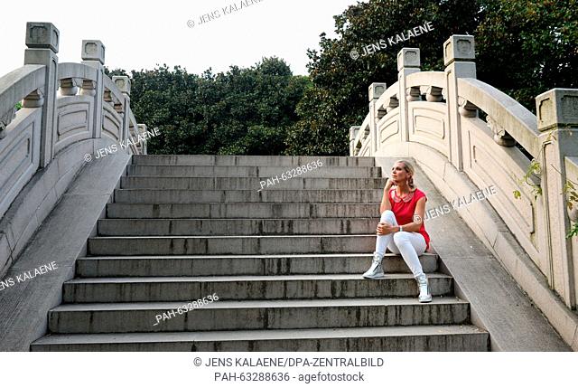 dpa-Exclusive - Maja Synke, Princess of Hohenzollern, sits on the steps of a stone bridge in the botanic garden in Shanghai, China, 31 August 2015