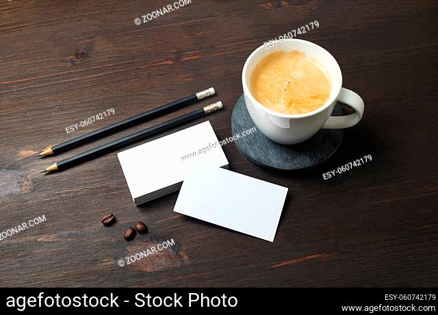 Blank business cards, pencils and coffee cup on wooden background. Template for ID