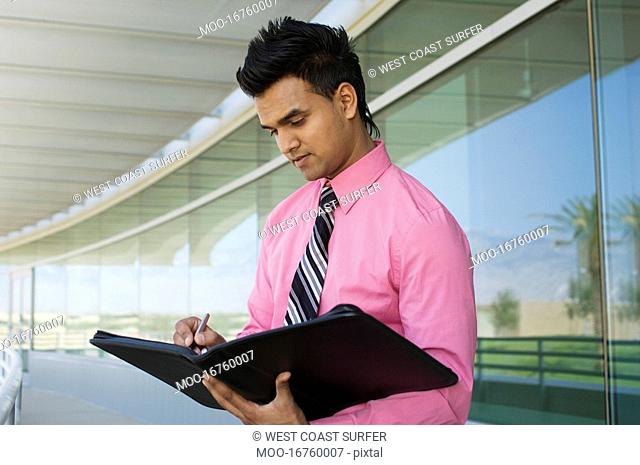 Businessman Writing in a Planner