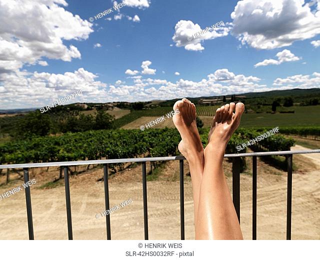 Woman resting feet on railing outdoors