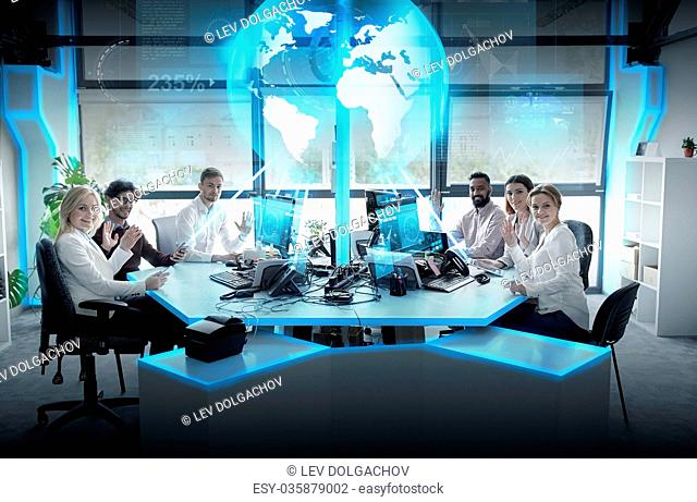 global network, technology and people concept - business team with computers waving hands at office
