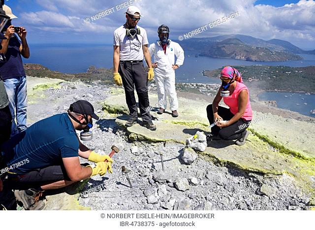Volcanologists check sulfur fumaroles and chloride crusts on the crater rim, Gran Cratere, Vulcano Island, Aeolian Islands, Sicily, Italy