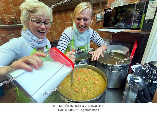 Stefanie Nowacka (R) and her mother Silke Nowacka-Paetzold (L) make pea stew in their restaurant 'Suppengruen' in Wismar, Germany, 05 November 2013