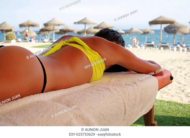 Massage area on the beach with suntanned beautiful woman lying down on summer vacation season