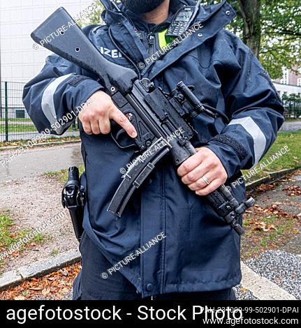 09 October 2023, Hamburg: A policeman with a submachine gun guards the Jewish synagogue in Hamburg with others after the Hamas attack on Israel