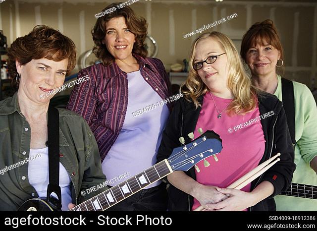 Portrait of Garage band composed of middle aged women, practicing in residential garage