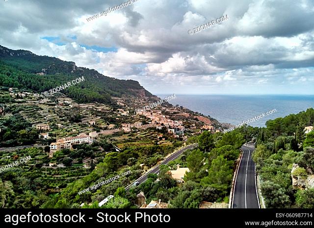 Aerial view coastal small hillside Banyalbufar town on west coast of Mallorca. Surrounded by Tramuntana mountain range district nestles among smaller peaks
