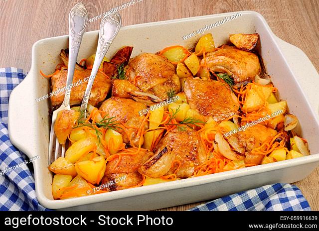 Braised roast chicken and vegetables in ceramic roasting pan