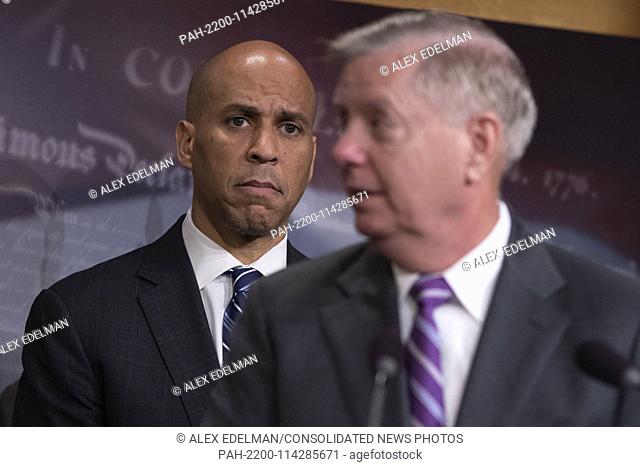 Senator Cory Booker, Democrat of New Jersey, looks on as Senator Lindsey Graham, Republican of South Carolina, speaks during a news conference celebrating the...