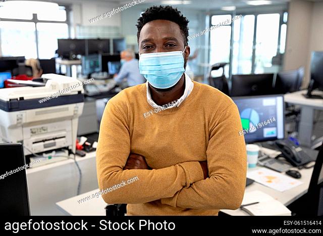 Portrait of businessman wearing face mask at modern office