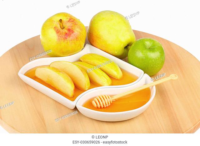apples and dipping slices of apple in honey for Rosh HaShanah, the Jewish New Year