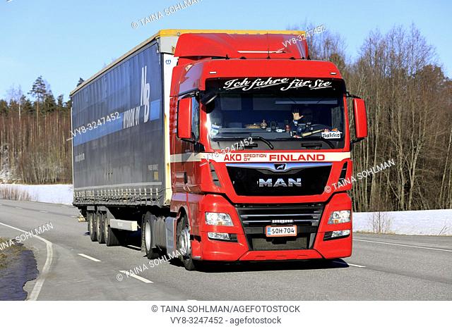 Salo, Finland - February 22, 2019: Red MAN TGX 18. 450 truck of AKO Spedition Oy pulls cargo trailer along highway in South of Finland on day of winter