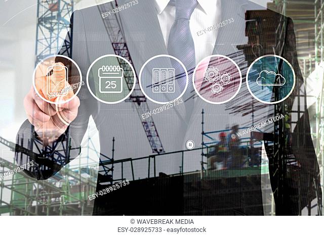 Composite image of man touching digital board against cranes