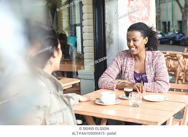 Friends talking at sidewalk cafe