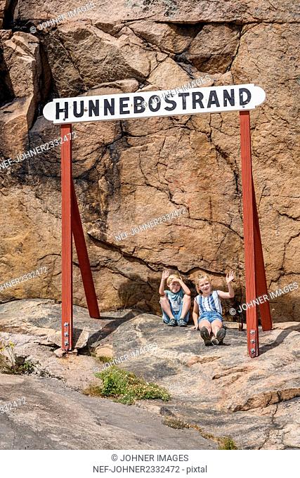 Children sitting under sign, Hunnebostrand, Gotaland, Sweden