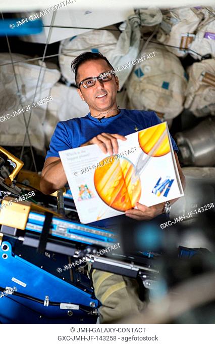 Flight Engineer Joe Acaba holds a children's book that he is reading from as part of the Story Time From Space program. Astronauts read aloud from a...