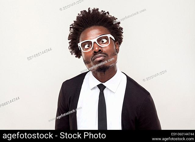 Portrait choke man in white glasses grimacing at camera. Studio shot, gray background