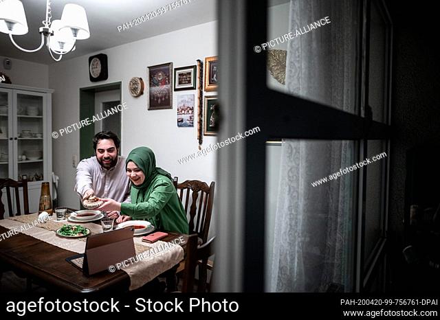 17 April 2020, North Rhine-Westphalia, Bochum: Rabia and Yusuf Simsek are sitting together at dinner and talking on the phone with friends