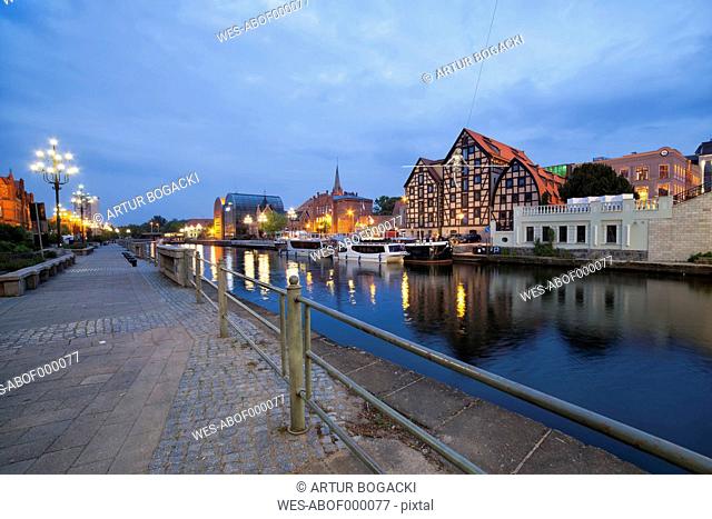 Poland, Bydgoszcz, cityscape at dusk along Brda River with old granaries