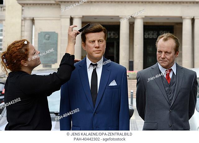 Media representative Nina Zerbe (L) works on the Madame Tussaud's wax figures of former US President John F. Kennedy (C) and former German Chancellor Willy...