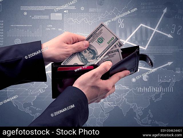 Businessman's hand takes out dollar from wallet with finance graphic on the background