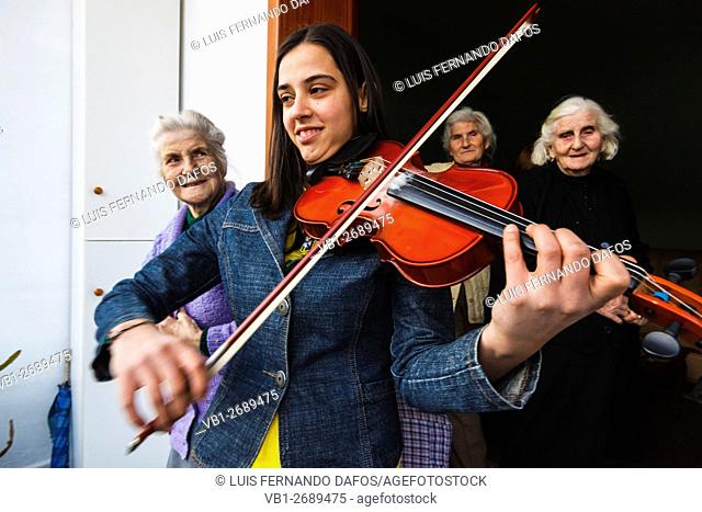 A young girl plays violin for her family celebrating Diten E Veres Summer Day festival. Elbasan, Albania